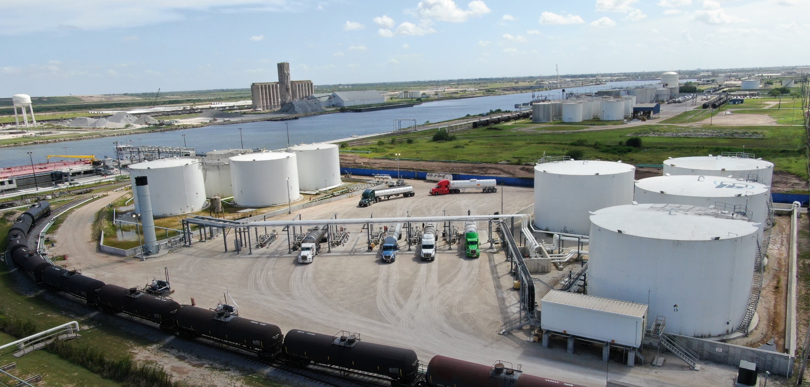 Aerial view of the Bluewing terminal at the Port of Brownsville: tank farm, truck loading rack, railcars and the ship channel